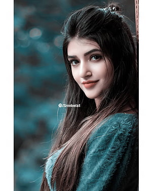 Portrait of a woman with long dark hair wearing a teal fuzzy sweater against a blurred background, 39 Sree Leela ideas, sreeleela HD phone wallpaper