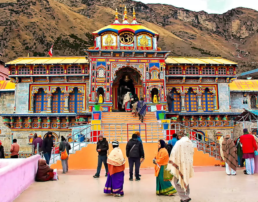 Badrinath Temple in the Himalayas with Devotees and Vibrant Architecture HD wallpaper