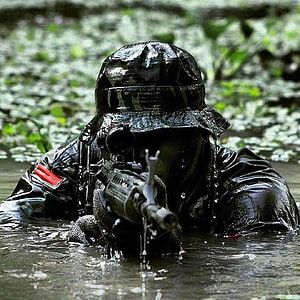 Indonesian Army Soldier in Camouflage Gear Holding Rifle in Shallow Water HD phone wallpaper
