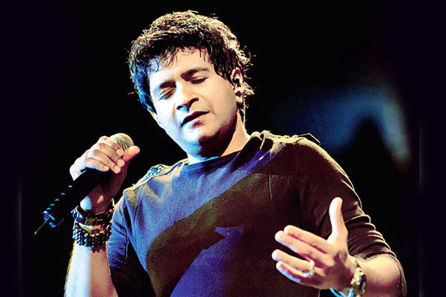 A male singer performs passionately on stage holding a microphone with eyes closed HD wallpaper