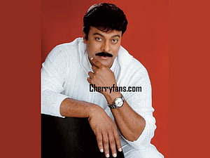 Chiranjeevi in a white sweater posing against a red background HD wallpaper
