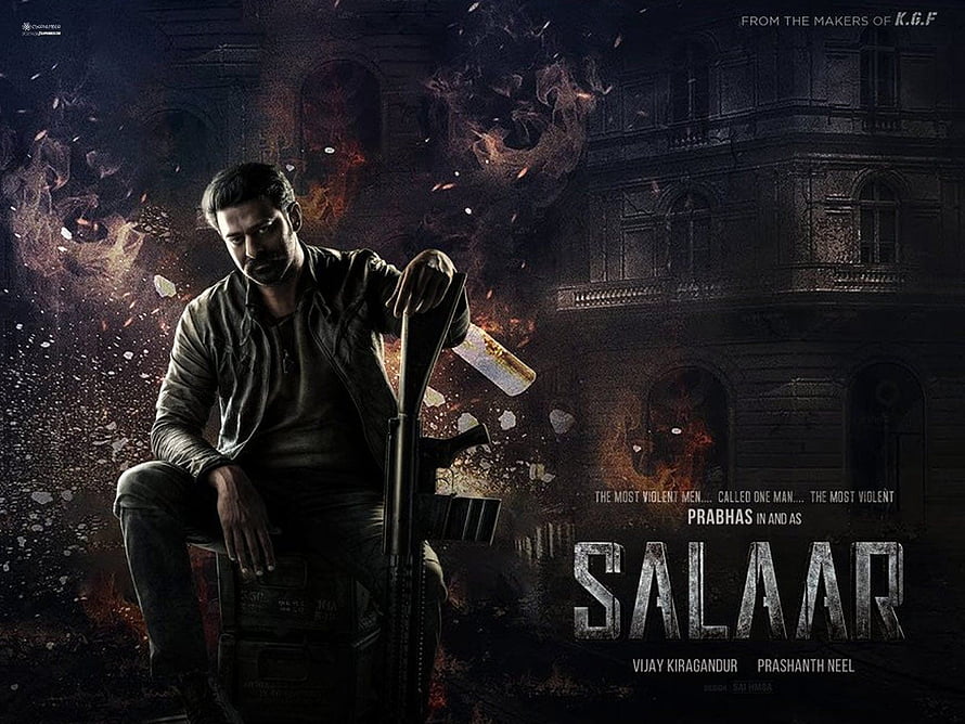 Prabhas as Salaar holding a rifle in a dark cinematic action movie poster with fire and debris HD wallpaper