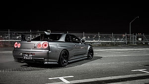 Nissan Skyline GT-R R34 Rear Three-Quarter View in Nighttime Parking Lot HD wallpaper