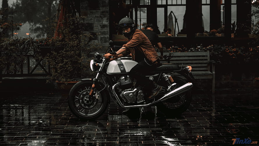 Retro Triumph Motorcycle Rider on Wet Cobblestone Street HD wallpaper