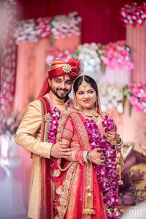 Indian Bride and Groom in Traditional Red and Gold Wedding Attire with Floral Garlands HD phone wallpaper