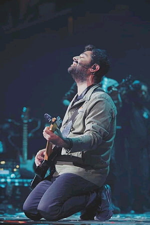 Michael Buble Kneeling On Stage Playing Guitar With Passionate Expression HD phone wallpaper