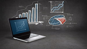 Laptop with data charts and graphs on a dark chalkboard background HD wallpaper