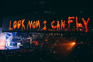 Look Mom I Can Fly concert stage with flaming text and performer HD wallpaper