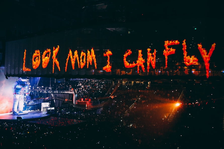 Look Mom I Can Fly concert stage with flaming text and performer HD wallpaper