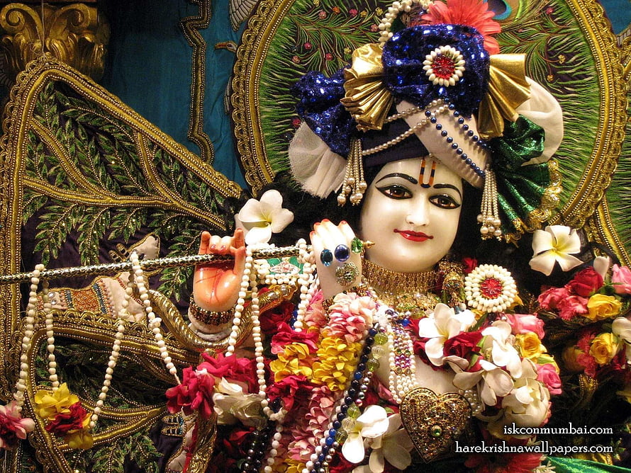 Ornate Krishna Murti Adorned With Fresh Flowers, Pearls, And Gold Jewelry HD wallpaper