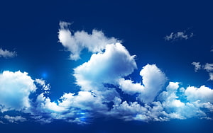 Stunning White Fluffy Clouds Drifting Across a Deep Blue Sky HD wallpaper