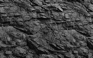 Dark Layered Rock Face Texture with Deep Rugged Surface Details HD wallpaper
