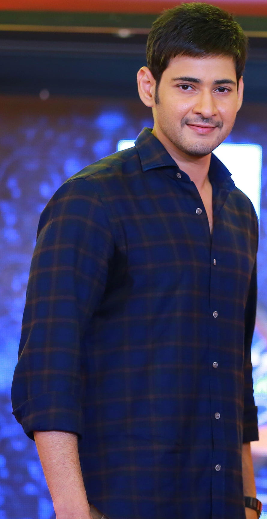 Mahesh Babu in a dark plaid shirt at a Tollywood event with a blue bokeh background HD phone wallpaper