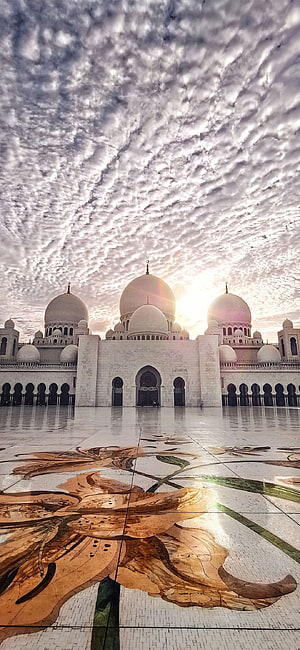 Sheikh Zayed Grand Mosque Abu Dhabi with dramatic clouds and floral mosaic courtyard HD phone wallpaper