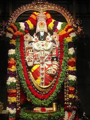 Decorated Hindu Deity Statue with Colorful Flower Garlands and Golden Crown HD phone wallpaper
