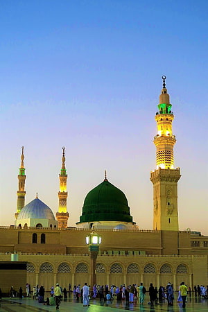 Al-Masjid an-Nabawi in Medina with the iconic Green Dome and illuminated minarets at dusk HD phone wallpaper