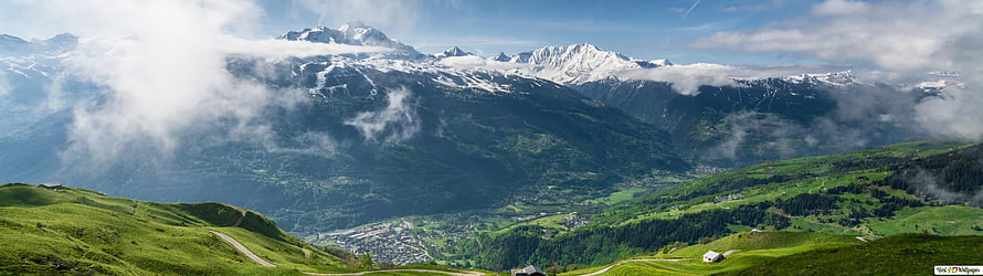 Panoramic View of Snow-Capped Alps Overlooking a Lush Green Valley and Village HD wallpaper