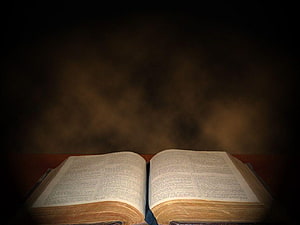 Open Bible on Wooden Surface with Dramatic Dark Background and Warm Lighting HD wallpaper
