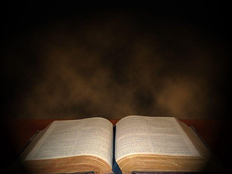 Open Bible on Wooden Surface with Dramatic Dark Background and Warm Lighting HD wallpaper