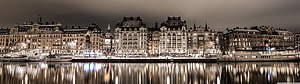 Paris Seine Riverfront at Night with Illuminated Haussmann Buildings and Boats HD wallpaper