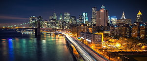 New York City Skyline at Night with Brooklyn Bridge and East River Light Trails HD wallpaper
