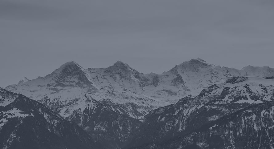 Majestic Snow-Capped Mountain Range Under Overcast Grey Sky HD wallpaper