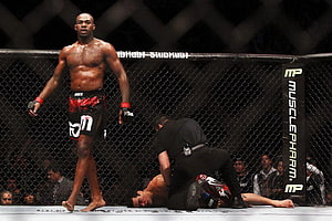 Jon Jones standing victorious in the UFC octagon after a knockout finish HD wallpaper
