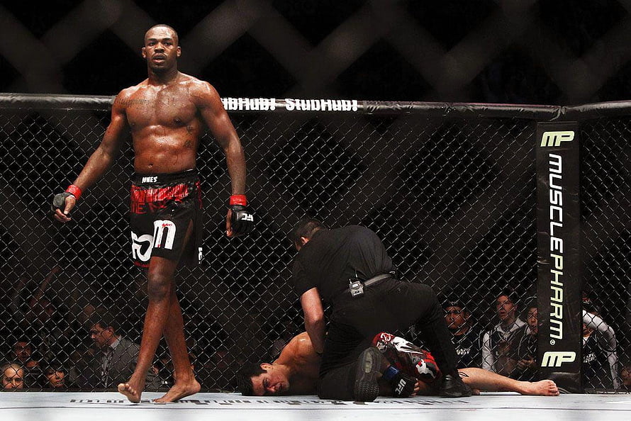Jon Jones standing victorious in the UFC octagon after a knockout finish HD wallpaper