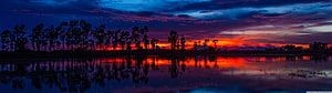 Vibrant Sunset Over Lake With Silhouetted Trees And Colorful Sky Reflection HD wallpaper