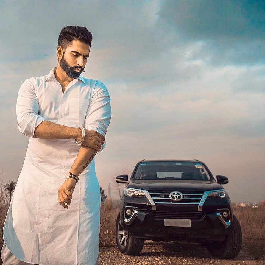 Parmish Verma in white kurta standing beside a black Toyota Fortuner SUV under a cloudy sky HD phone wallpaper