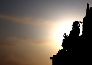 Silhouette of a traditional temple roof against a glowing sunset sky HD wallpaper