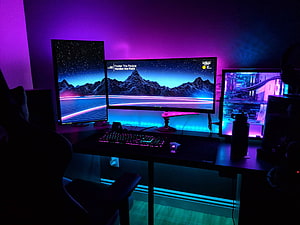 Neon Purple and Blue Gaming Setup with Retro Mountain Wallpaper and RGB Lighting HD wallpaper