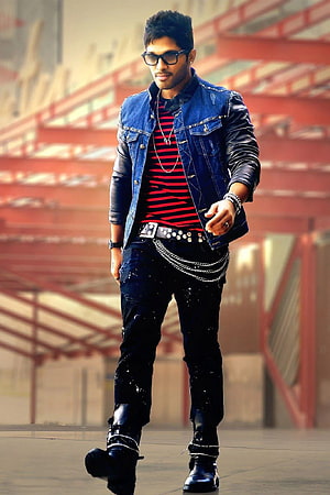 Allu Arjun in a denim jacket, striped shirt, and studded boots against an industrial backdrop HD phone wallpaper