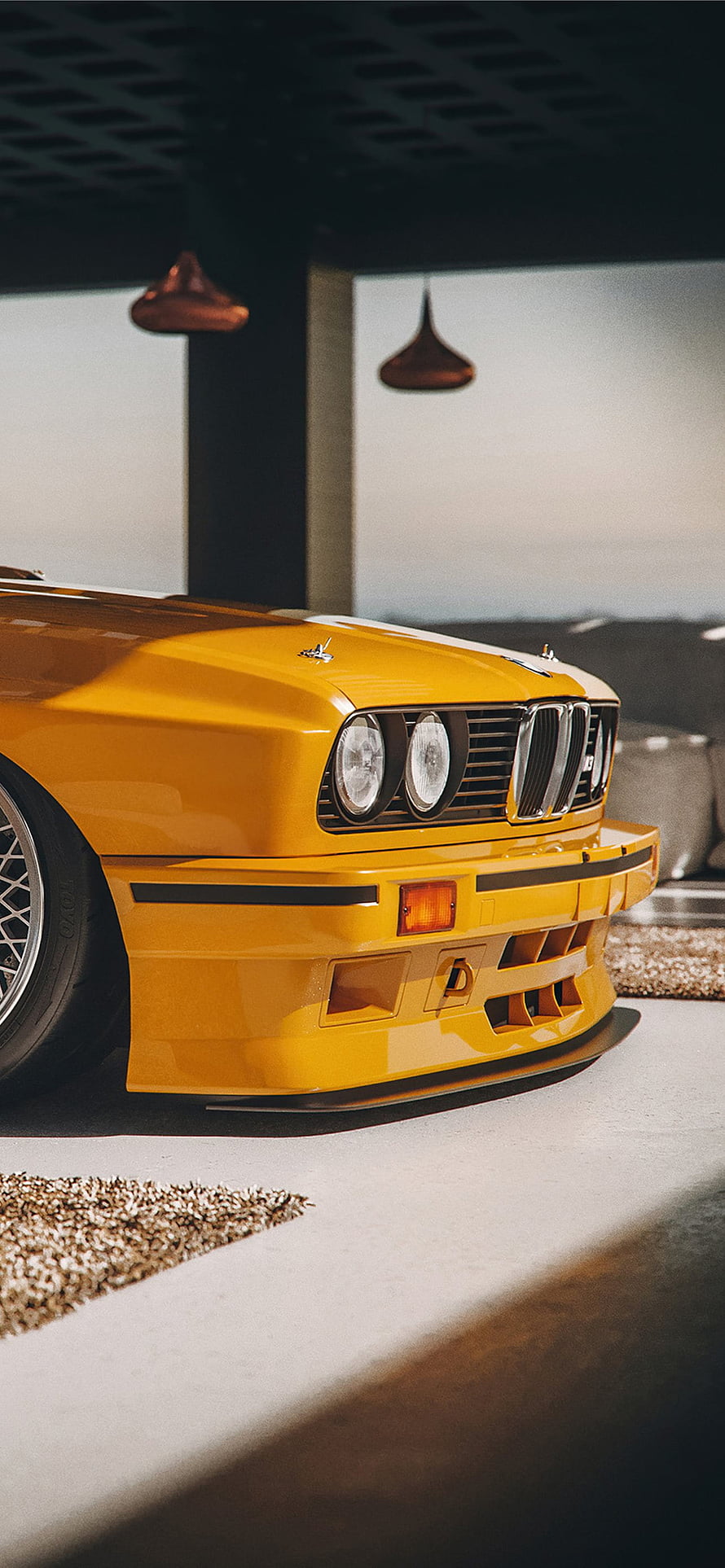 Classic Yellow BMW E30 M3 Front End Detail in Modern Garage Setting HD phone wallpaper
