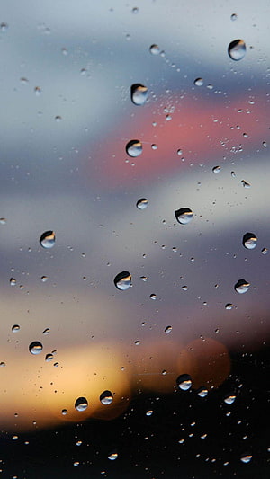 Raindrops on Glass with Blurred Sunset Bokeh Background HD phone wallpaper