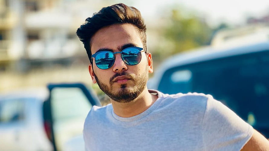 Elvish Yadav Wearing Blue Sunglasses and White T-Shirt in Outdoor Setting HD wallpaper