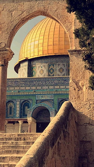 Dome of the Rock in Jerusalem framed by a historic stone archway HD phone wallpaper