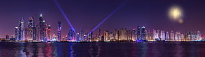 Panoramic Night Skyline of a Modern City with Fireworks and Laser Beams Over Water HD wallpaper