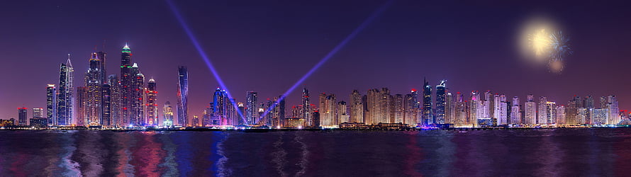 Panoramic Night Skyline of a Modern City with Fireworks and Laser Beams Over Water HD wallpaper