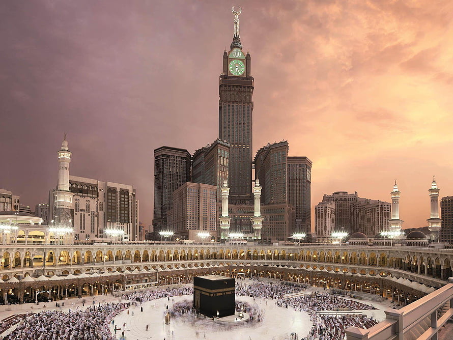 Makkah Clock Tower and the Grand Mosque at sunset with pilgrims performing Tawaf around the Kaaba HD wallpaper