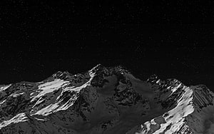 Snow-Covered Mountain Peaks Under a Starry Night Sky in Black and White HD wallpaper