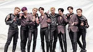 Stray Kids in coordinated leather suits and taupe blazers posing against a white backdrop HD wallpaper