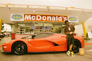 Man leaning on orange Ferrari LaFerrari at McDonald's drive-thru, Travis Scott x McDonald's: How a Burger Order Becomes a Grail, travis scott burger HD wallpaper
