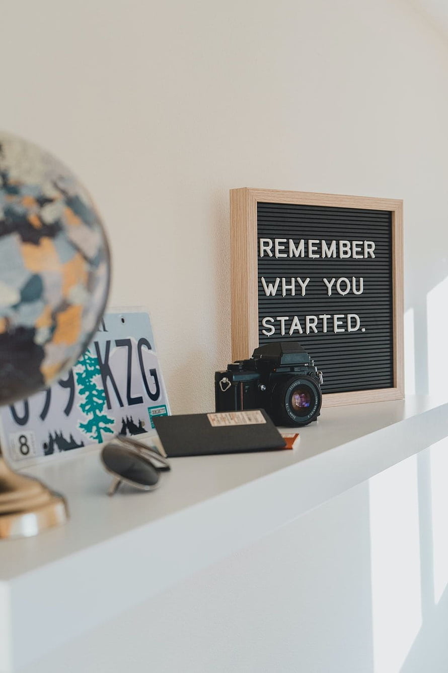 Minimalist Desk Setup With Globe, Vintage Camera, and Motivational Letter Board HD phone wallpaper