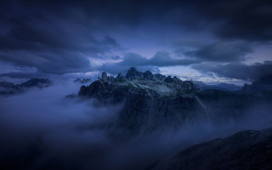 Mystical Mountain Peaks Rising Above Thick Blue Fog and Clouds HD wallpaper