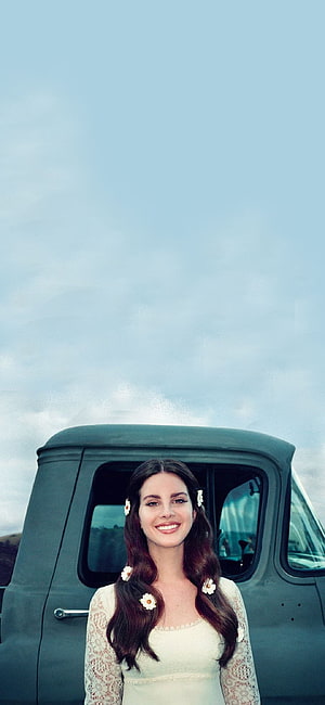 Lana Del Rey in a vintage car with daisy hair accessories and a lace top HD phone wallpaper
