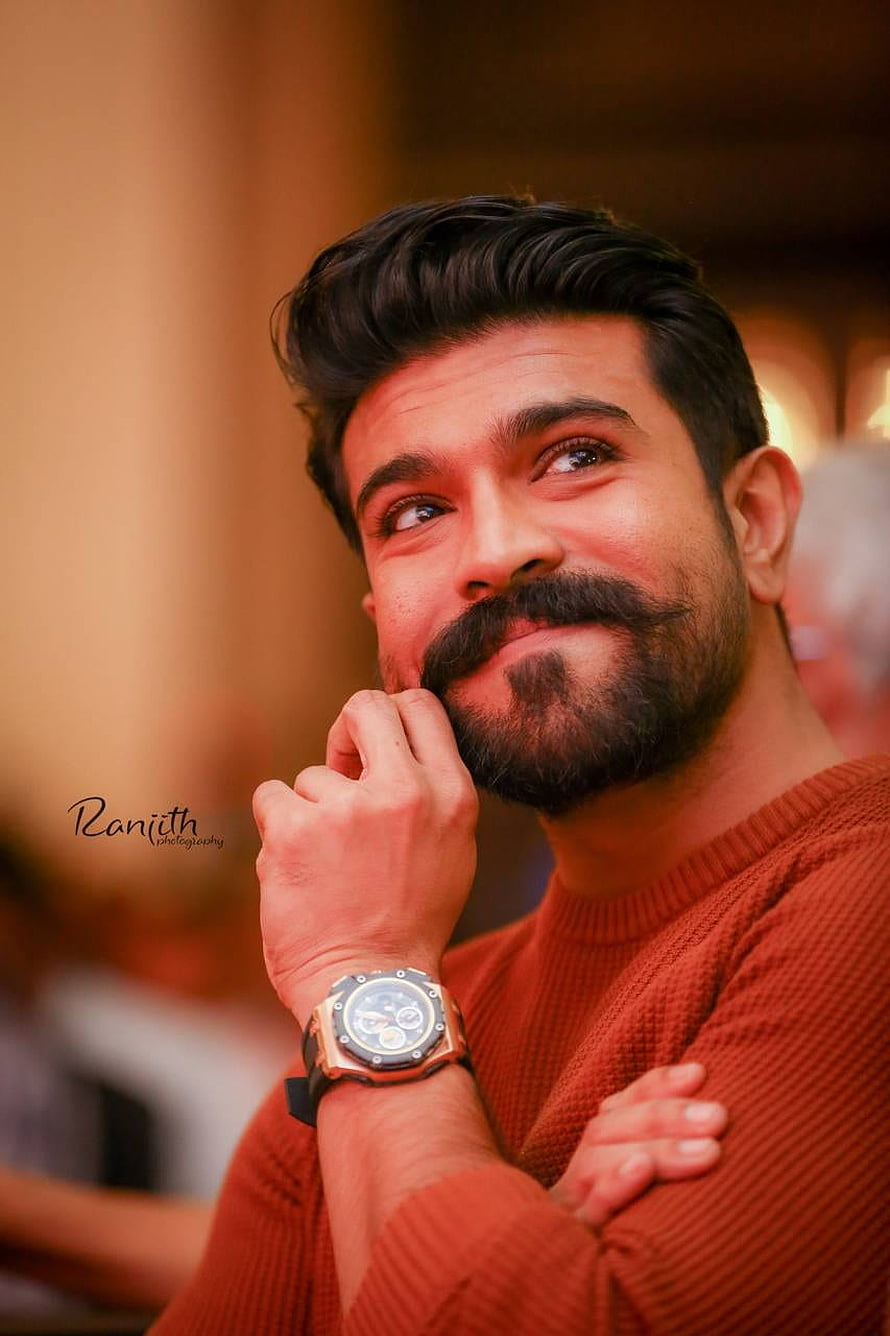 Portrait of Indian actor Ram Charan in a rust sweater with a luxury watch HD phone wallpaper