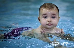 Cute Baby Swimming in Pool with Purple Floatie HD wallpaper