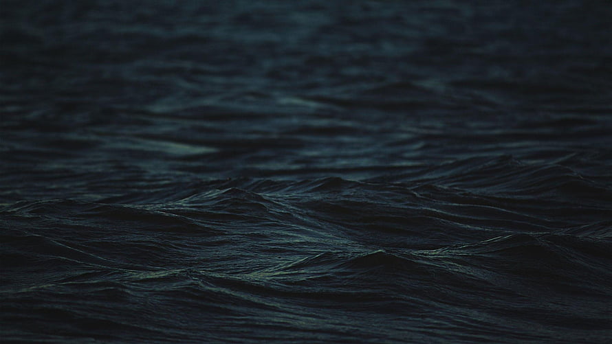 Dark Ocean Waves at Night with Deep Blue Tones and Subtle Surface Ripples HD wallpaper