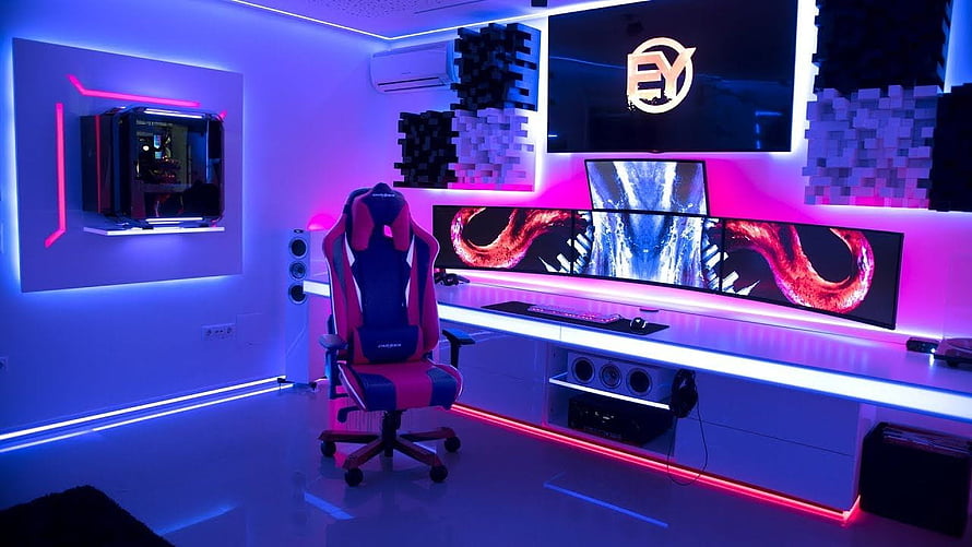 Neon-lit gaming room with RGB LED strips, triple monitor setup, and a red and blue gaming chair HD wallpaper